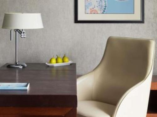 a desk with a chair and a table with a lamp at Fairmont Singapore in Singapore