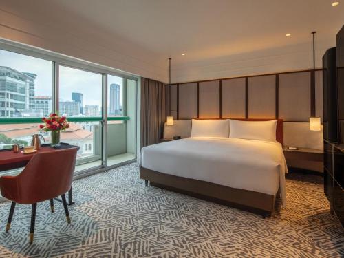 a hotel room with a bed and a desk and a desk at Fairmont Singapore in Singapore
