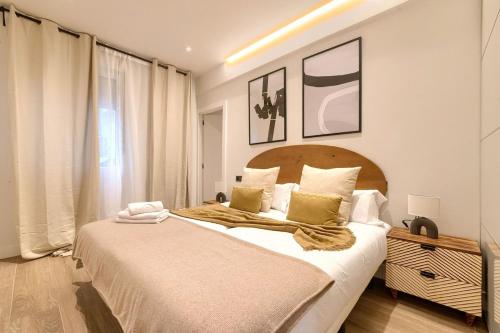 a bedroom with a large bed with a wooden headboard at San Mamés Apartment in Bilbao