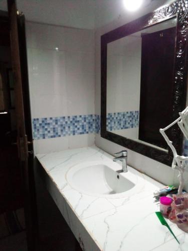 a bathroom with a sink and a large mirror at Haki Villas in Gatunga