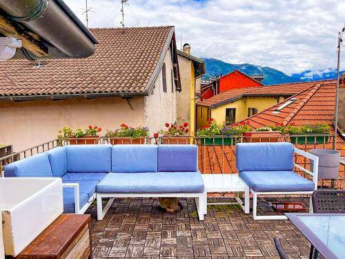 un patio con muebles azules y blancos en un balcón en Terrazza sul tetto, en Cannobio