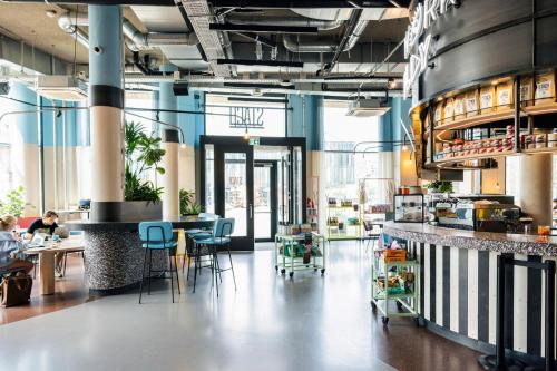 a room with tables and chairs in a restaurant at The Social Hub Delft Extended Stay in Delft