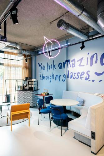 a room with a table and chairs and a wall with writing at The Social Hub Delft Extended Stay in Delft