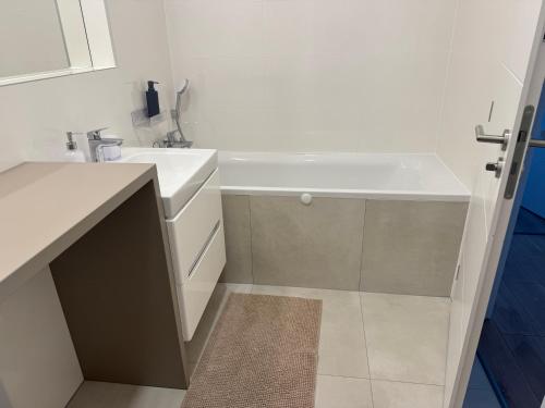 a bathroom with a sink and a bath tub at Apartmán pod Tatrami K2 in Poprad