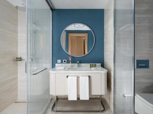 a bathroom with a sink and a mirror at Rixos Water World Aktau - Theme Park Free Access in Aktau