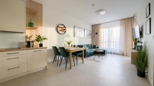 a kitchen and dining room with a table and chairs at Olympic Park I, Sun & Snow in Kołobrzeg