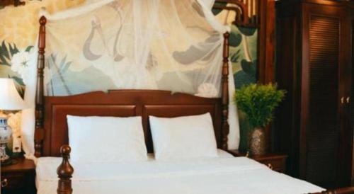 a bedroom with a bed with a wooden head board at Jun's Home in Buon Ma Thuot