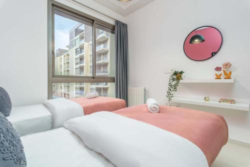 DbayehにあるViva - Elegant 3-BR Apt & Balcony at Waterfront Dbayehの白とピンクの家具と窓のあるリビングルーム