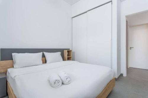 a bedroom with a large white bed with towels on it at Sketch - Innovative 1-BR Apt by Convivium IX in Monot in Sodeco