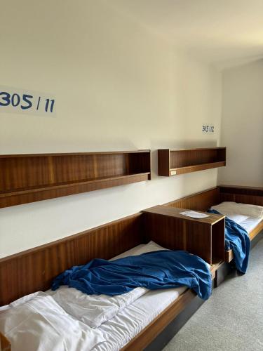 a bedroom with two bunk beds with blue sheets at NUMBR25 - self service & low budget Hotel in Graz