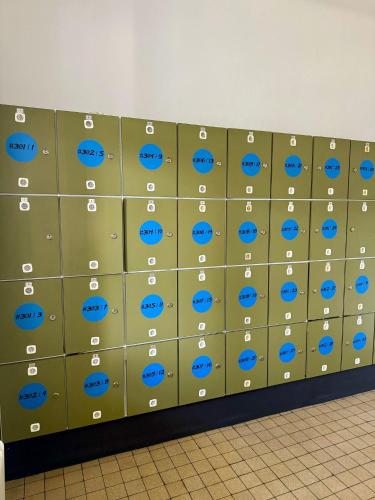 a wall of lockers with blue eyes on them at NUMBR25 - self service & low budget Hotel in Graz