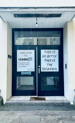 two signs on the front doors of a building at NUMBR25 - self service & low budget Hotel in Graz