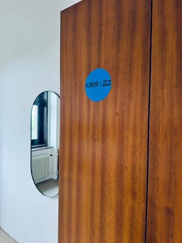 a wooden door with a round mirror on it at NUMBR25 - self service & low budget Hotel in Graz