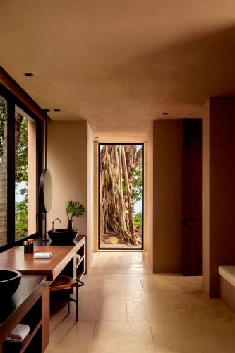 a bathroom with two sinks and a large tree at One&Only Mandarina in Lo de Marcos