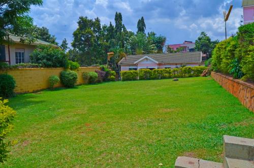 a yard with green grass and a house at Speta homes in Kampala