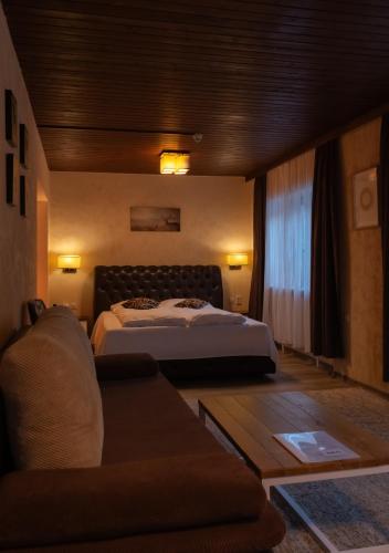 a hotel room with a bed and a couch at Alpenhotel Edelweiss in Maurach