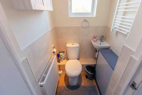 a small bathroom with a toilet and a sink at 3 Bedrooms - Sleeps 8 - Wifi - 3 Car Parking in Andover