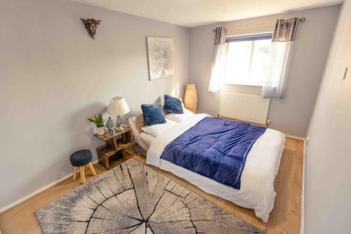a bedroom with a bed and a window and a rug at 3 Bedrooms - Sleeps 8 - Wifi - 3 Car Parking in Andover