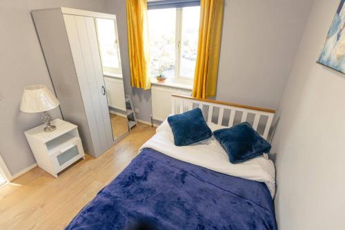a bedroom with a bed with two blue pillows on it at 3 Bedrooms - Sleeps 8 - Wifi - 3 Car Parking in Andover