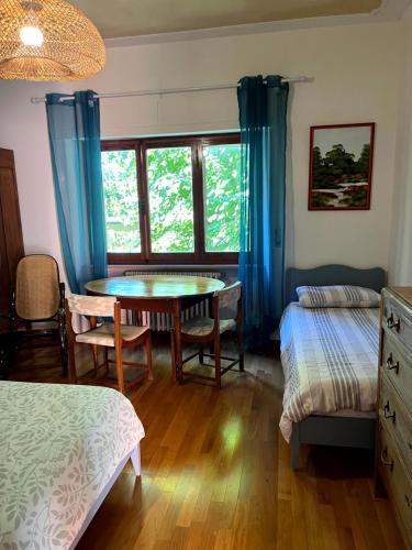 a bedroom with a table and a bed and a window at Villetta la Fortezza in Radicofani