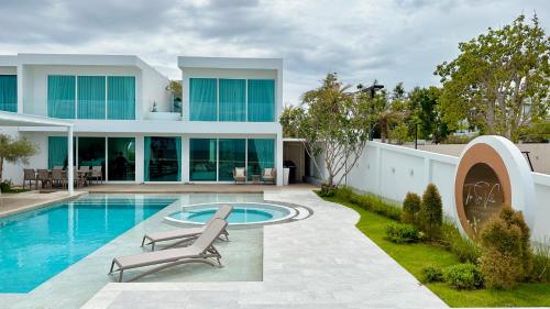 a villa with a swimming pool and a house at Topseavilla Poolmoon 2 bedroom in Ban Bo Yai