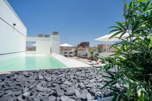 a swimming pool on the roof of a building at Limehome Sevilla Calle Torcuato Luca de Tena - Digital Access in Seville