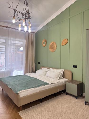 a bedroom with a large bed with green walls at Гостевой дом Burabay Grand Village in Borovoye