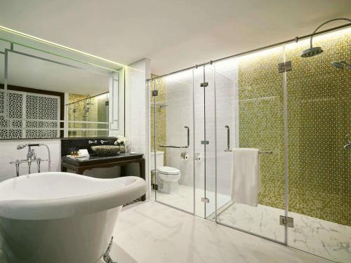 a bathroom with a shower and a sink and a toilet at Mövenpick Myth Hotel Patong Phuket in Patong Beach