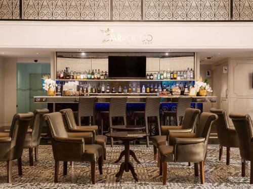 a bar in a room with chairs and a bar counter at Mövenpick Myth Hotel Patong Phuket in Patong Beach