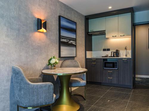 a kitchen and dining room with a table and chairs at The Sebel Wellington Lower Hutt in Lower Hutt