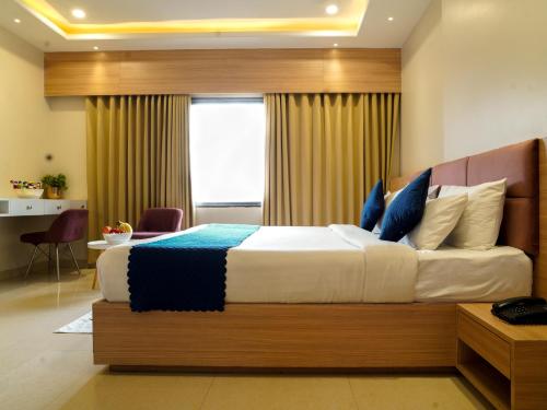 a bedroom with a large bed with blue pillows at Hotel Rudura Palace in Udaipur