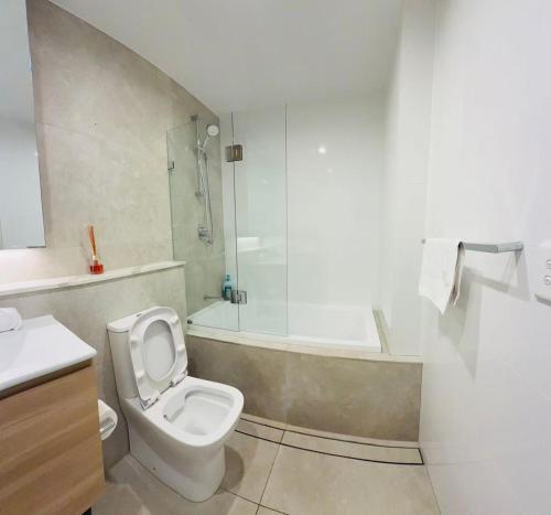 Un baño con inodoro, ducha y lavabo. en Schofields Brand New 2 Br Apt Parking Privacy, en Schofields