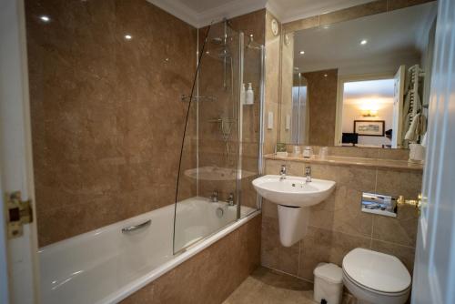 a bathroom with a sink and a toilet and a shower at Lindeth Howe in Bowness-on-Windermere