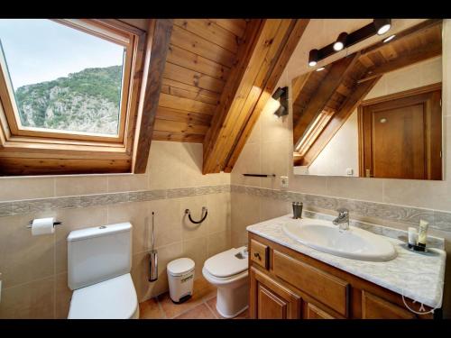 een badkamer met een wastafel en een toilet en een raam bij LIAT de Alma de Nieve in Bagergue