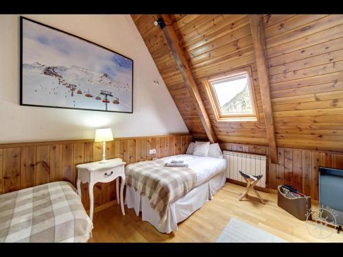 een slaapkamer met 2 bedden in een houten hut bij LIAT de Alma de Nieve in Bagergue