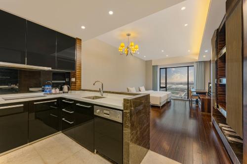 a kitchen with black cabinets and a living room at HeeFun Apartment GZ -Poly World Trading Center-walking distance to Canton Fair in Guangzhou