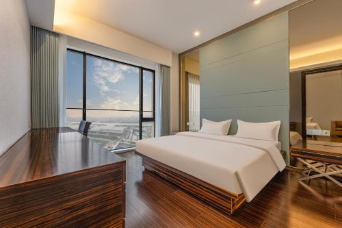 a bedroom with a large white bed and a desk at HeeFun Apartment GZ -Poly World Trading Center in Guangzhou