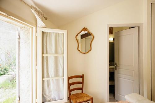 a room with a mirror and a chair next to a door at LaPetite Maison Abigail, Peaceful home in Avignon in Avignon