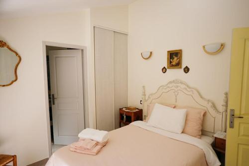 a bedroom with a white bed with a pink towel on it at LaPetite Maison Abigail, Peaceful home in Avignon in Avignon