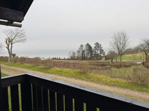 a balcony with a view of a field and the ocean at Kaløvig Beach Holiday Centre in Rønde