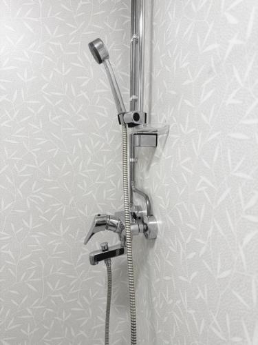 a shower in a bathroom with a shower head at Arctic Elf Apartment in Rovaniemi