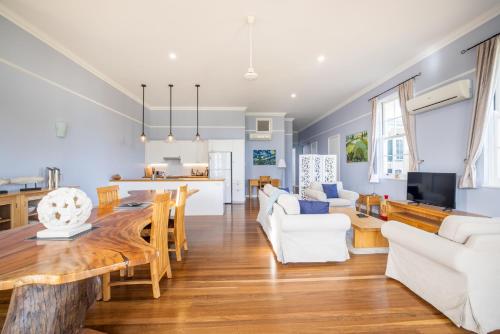 a living room with a wooden table and white furniture at Kernow - Minimum age 18 in Charters Towers