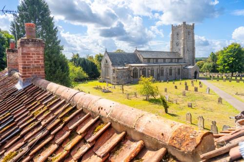an old building with a tower and a church at Cockleshells in Castle Acre