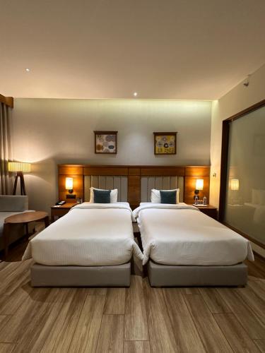 two beds in a hotel room with two bedsvisor at DNT Plaza in Morbi