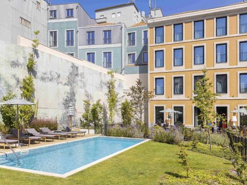 a courtyard with a swimming pool in front of a building at Mercure Porto Centro Aliados in Porto