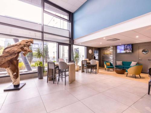 a lobby with a statue in the center of a building at Mercure Bale Mulhouse Aeroport in Blotzheim