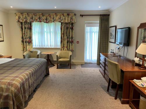a hotel room with a bed and a desk at Lindeth Howe in Bowness-on-Windermere