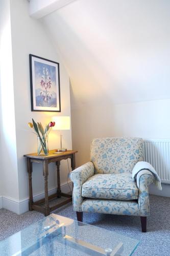 a living room with a chair and a table at Cranmere Lichfield in Lichfield