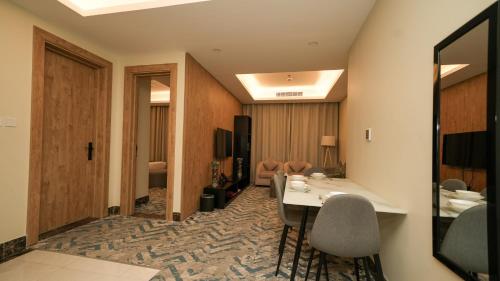 a hotel room with a table and chairs in a room at بنزرت للشقق المخدومة in Al Hofuf