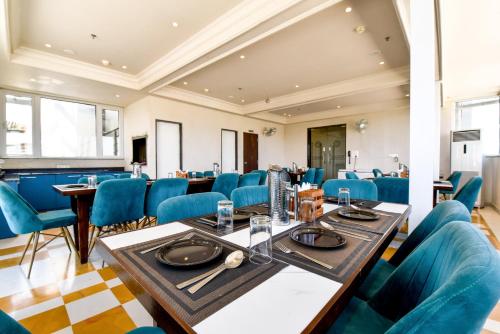a dining room with blue chairs and tables at Hotel Rudura Palace in Udaipur